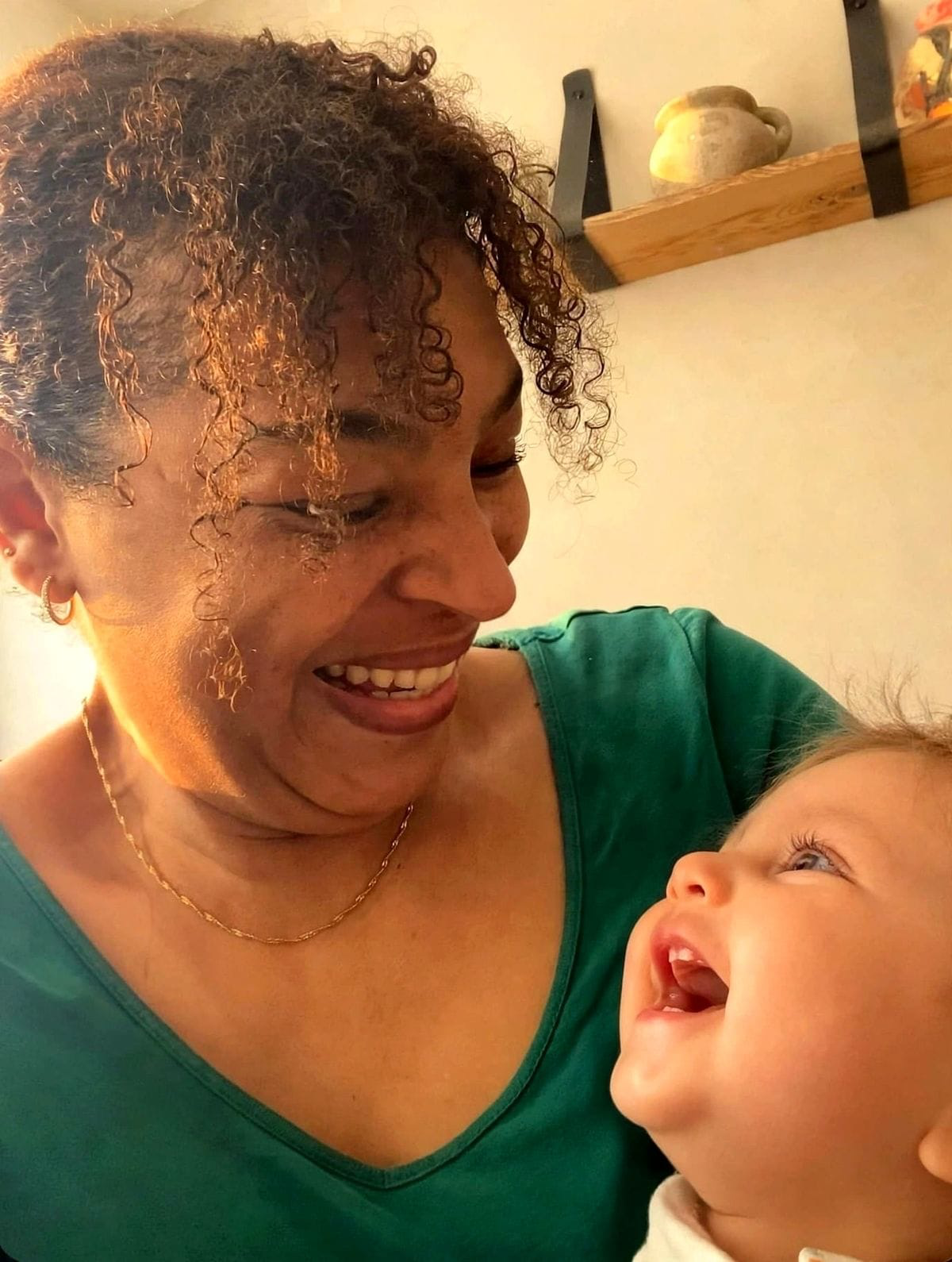 Maureen lacht samen met een baby'tje